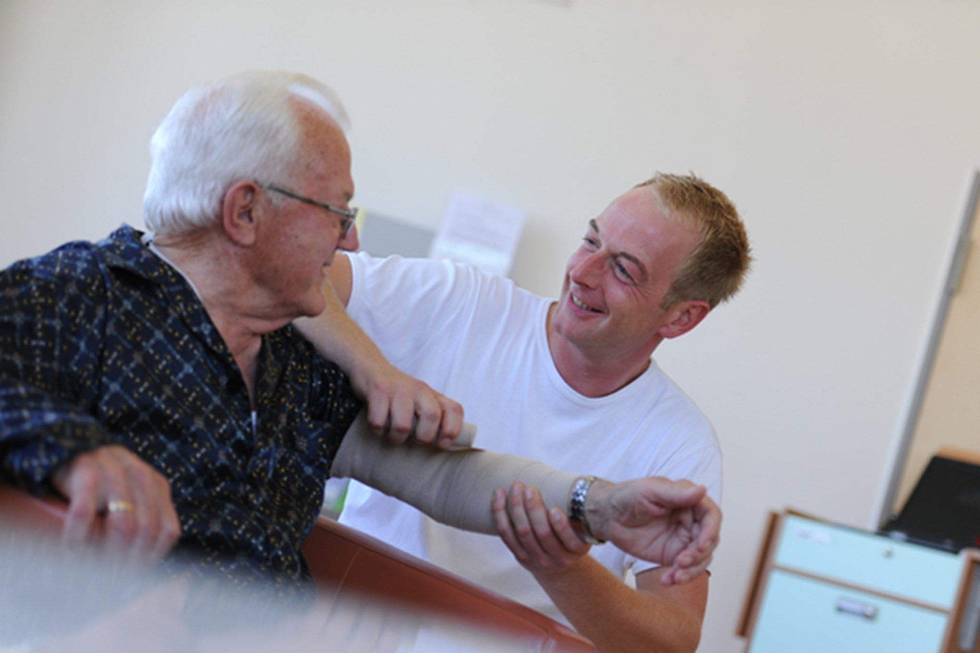 Pfleger verbindet Patient den Arm